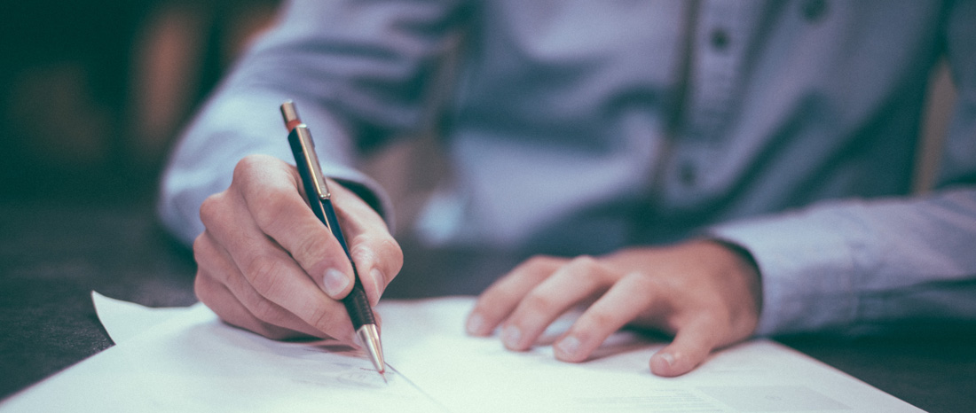 Person writing a trashcan cover letter with pen in hand